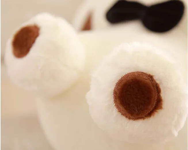 valge pehme mängukaru pruunide kõrvade ja musta lipsuga