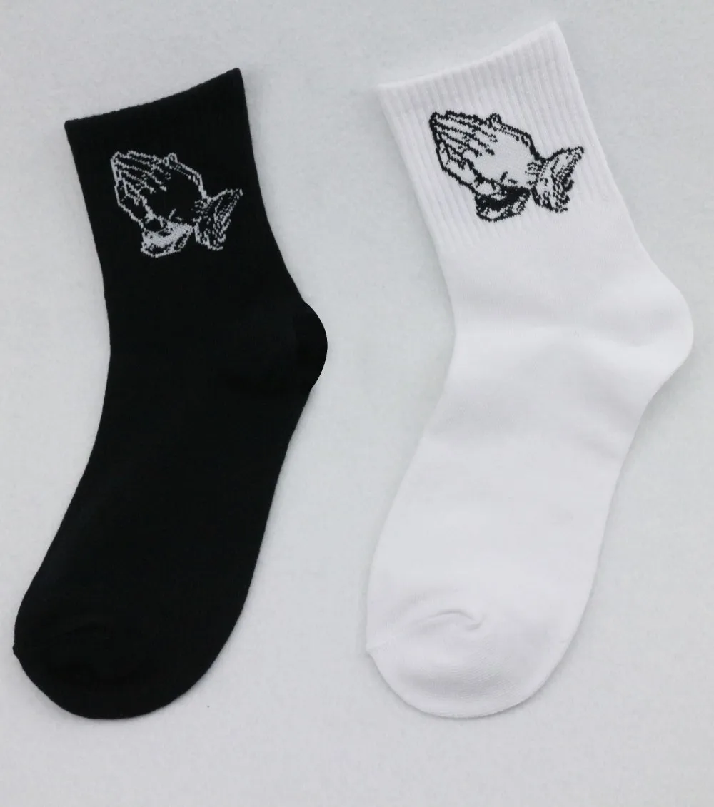 must ja valge puuvillane sokk palvetavate käte kujutisega