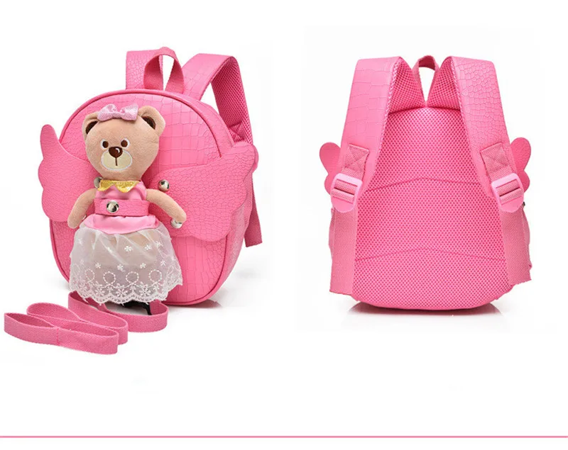 roosa seljakott karu ja inglitiibadega, ees karu mänguasi kleidis