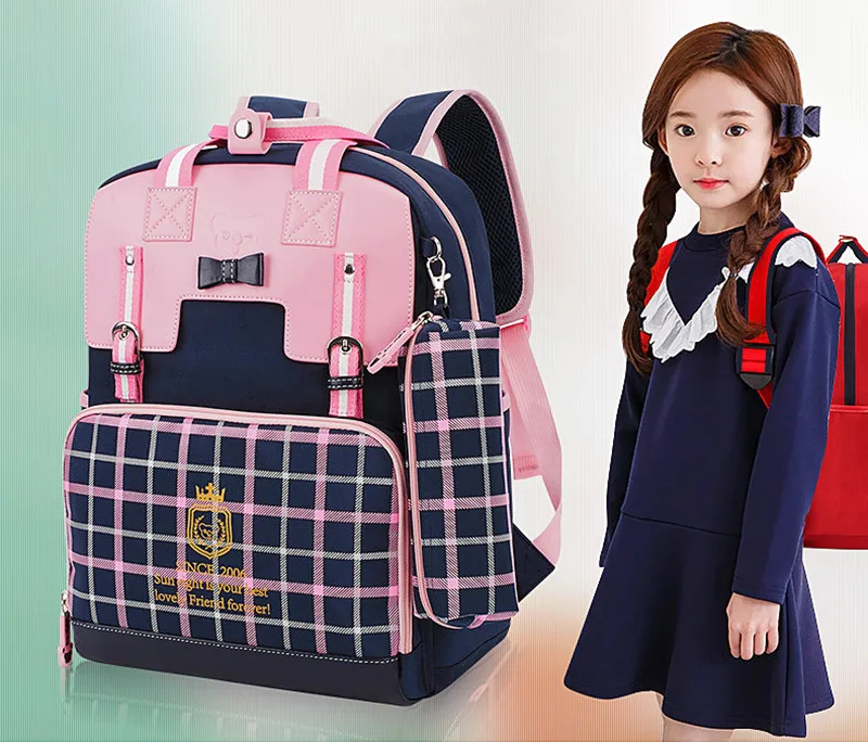 roosa ja sinise ruudulise mustriga koolikott, millel on ees tasku ja kaunistused