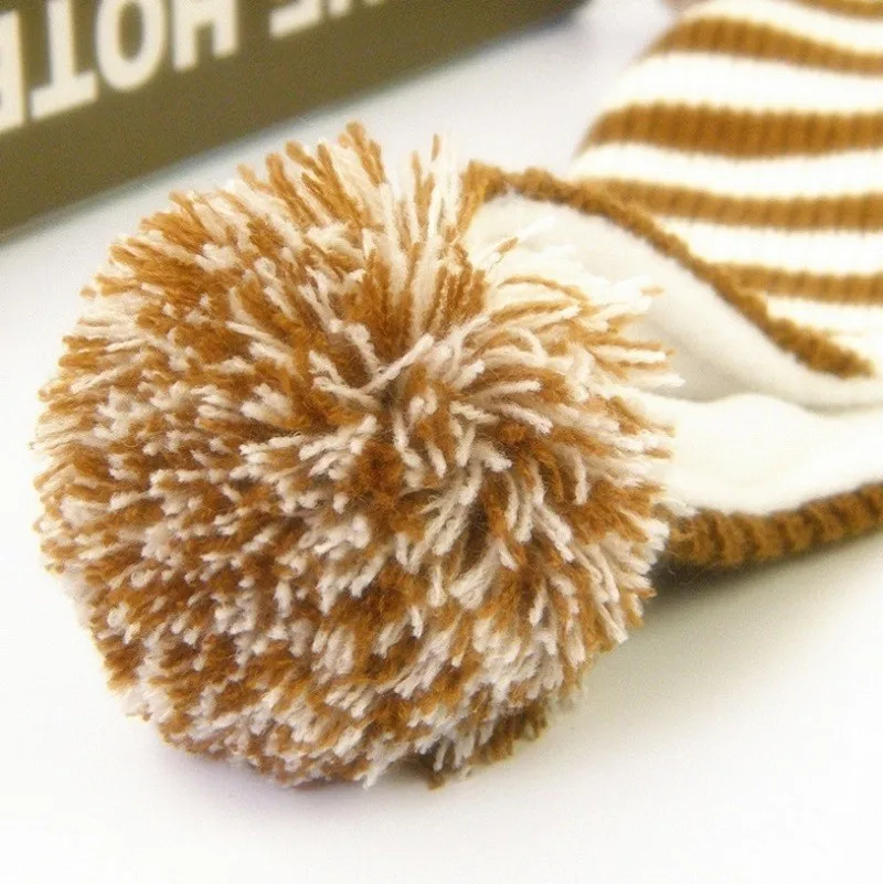 pruunide ja valgete triipudega laste müts, millel on suur tutt