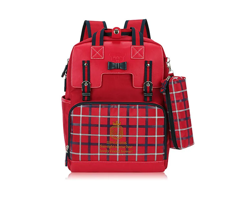 punane ruuduline koolikott, millel on ees tasku ja küljes väike kotike