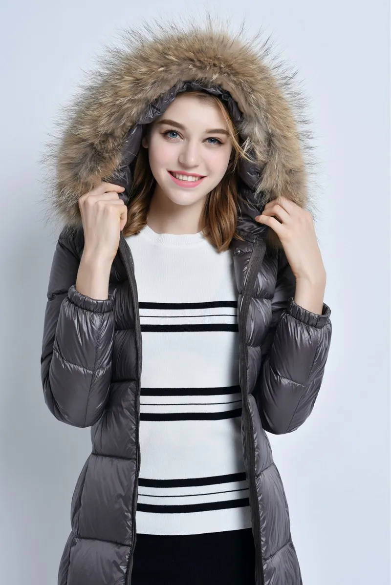 naine kannab kapuutsiga halli talvemantlit, millel on karusnahkne ääris