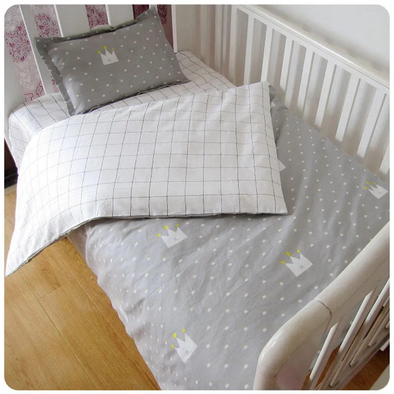 hall ja valge kolmeosaline voodipesukomplekt lastele, millel on ruuduline muster ja krooni kujutised