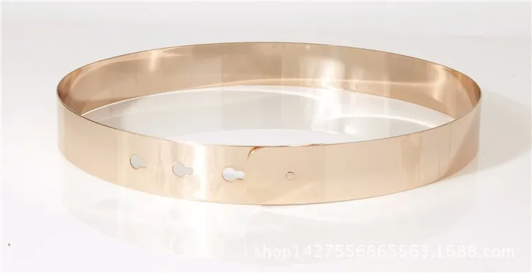 kuldne metallist pihavöö, millel on kolm auku