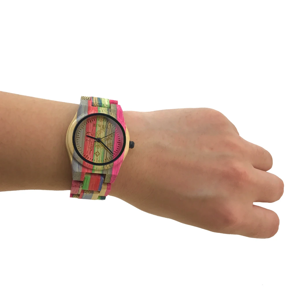 puidust käekell värvikireva randmerihmaga naise randmel