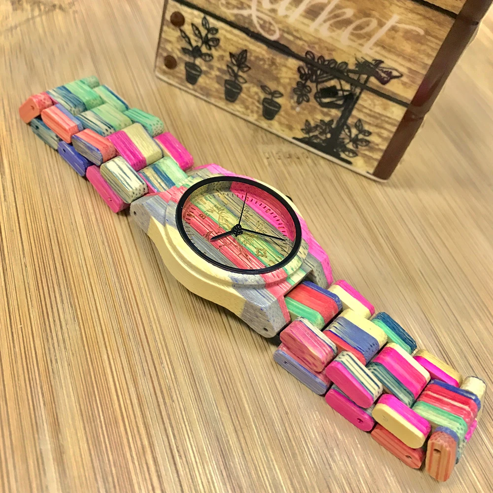 värvikireva randmerihmaga puidust käekell puidust laual