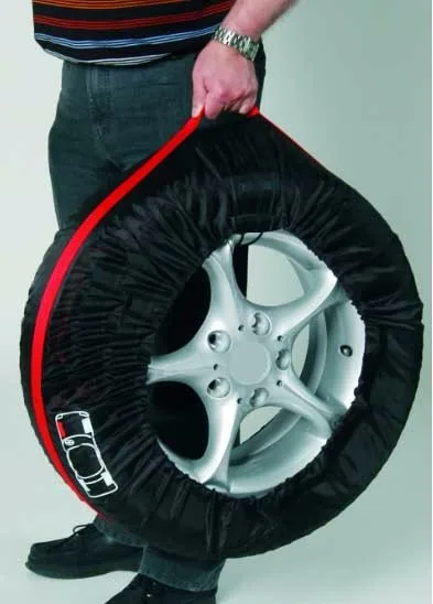 inimene hoiab musta ja punase servaga rehviümbrist, milles on hõbedane velg