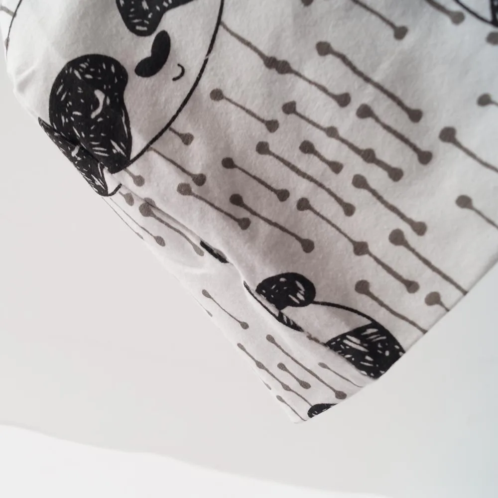 valge beebimüts mustade koeramustrite ja hallide triipudega