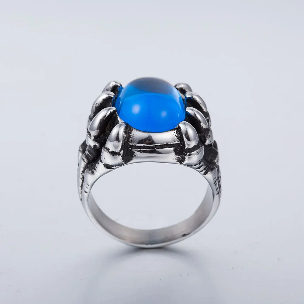 hõbedane sõrmus sinise kiviga, mida ümbritsevad lohe küünised