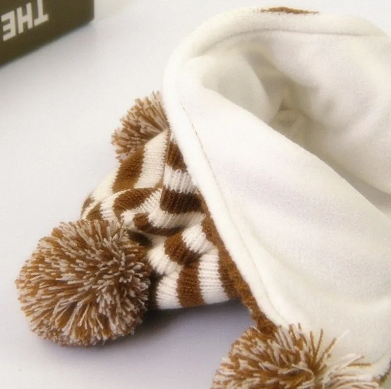 pruunide ja valgete triipudega laste müts, millel on neli tutikest