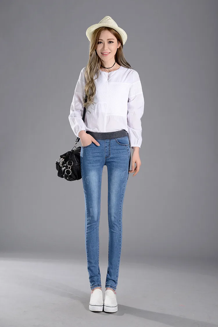 naine kannab siniseid stretš teksaseid ja valget pluusi