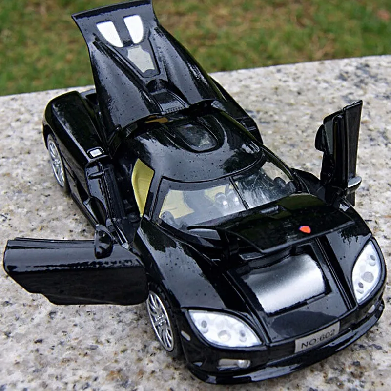 musta värvi sportauto mänguasi avatud uste ja kapotiga