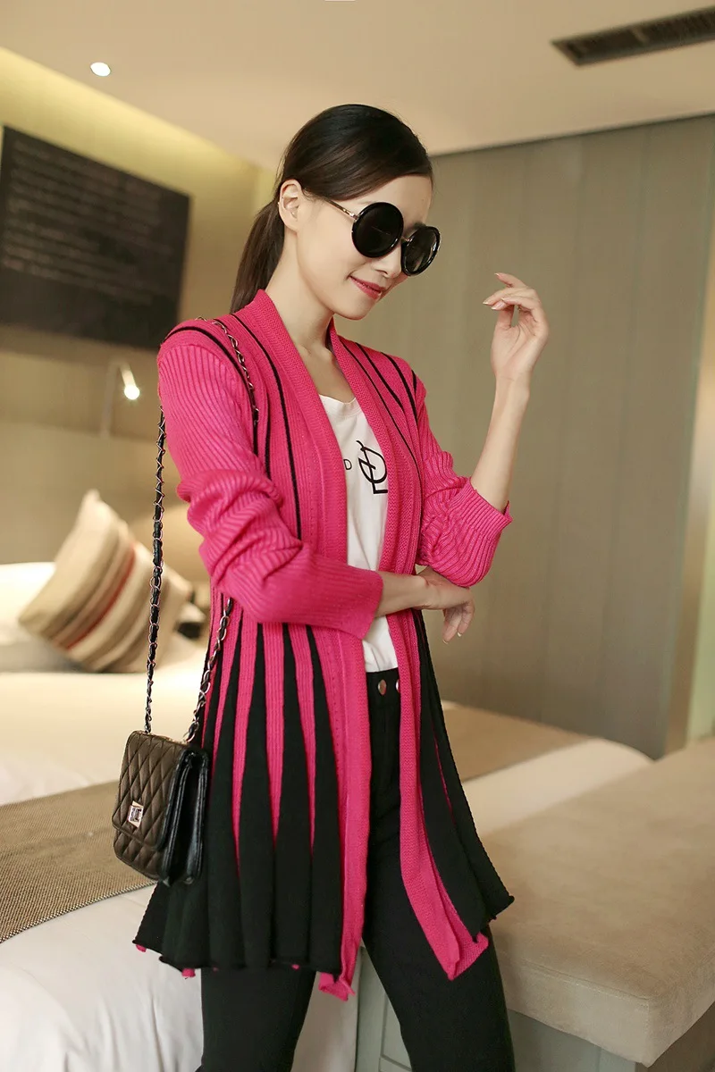 naine kannab roosat ja musta kardigani, millel on triibuline muster