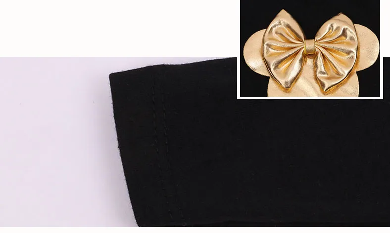 mustast kangast riideosa ja kuldne lipsukujuline detail