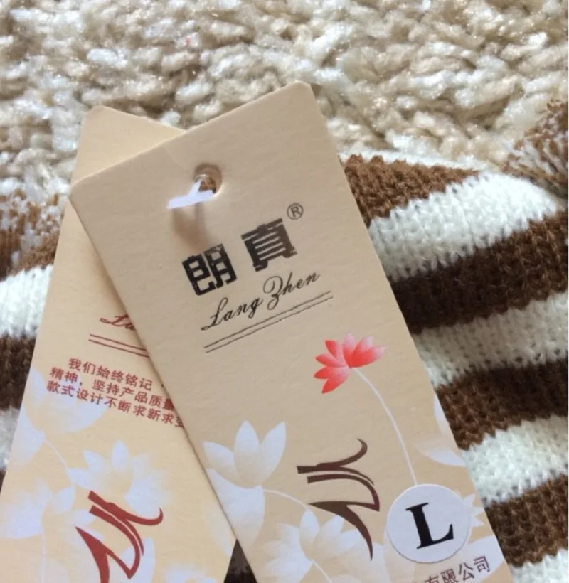 pruunide ja valgete triipudega kudum, millel on kaks sildiga etiketti