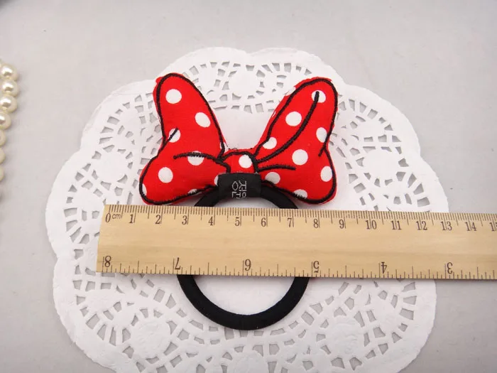 punane valgete täppidega lipsukujuline juuksekumm pitsalusel