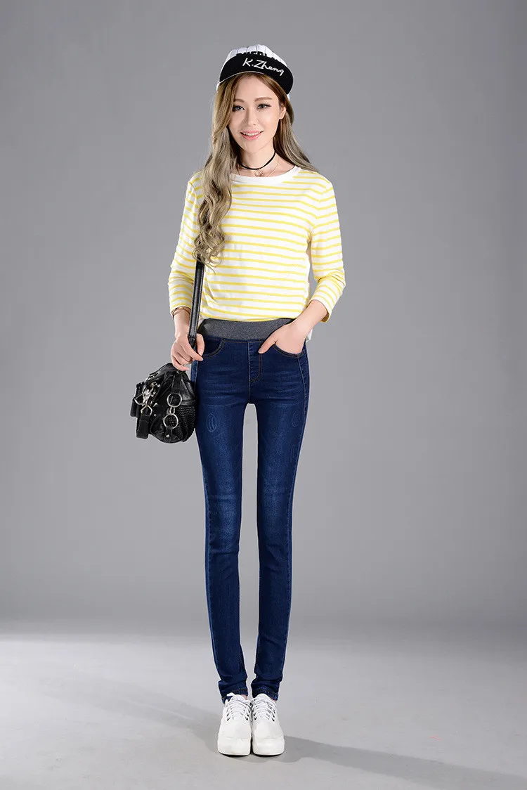 naine kannab tumesiniseid stretš teksaseid ja triibulist särki