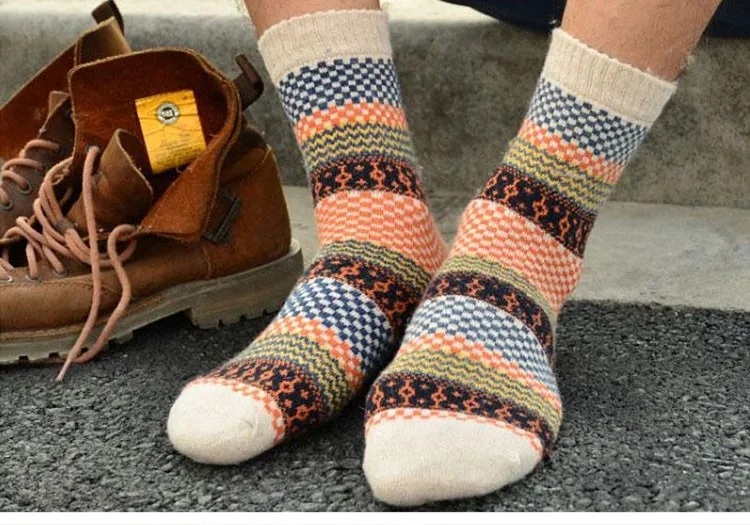 värvilised mustrilised villased sokid mehe jalgadel, taustal pruunid saapad