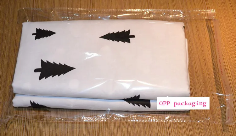 valge voodipesukomplekt mustade kuusepuu mustritega, pakitud läbipaistvasse kilekotti