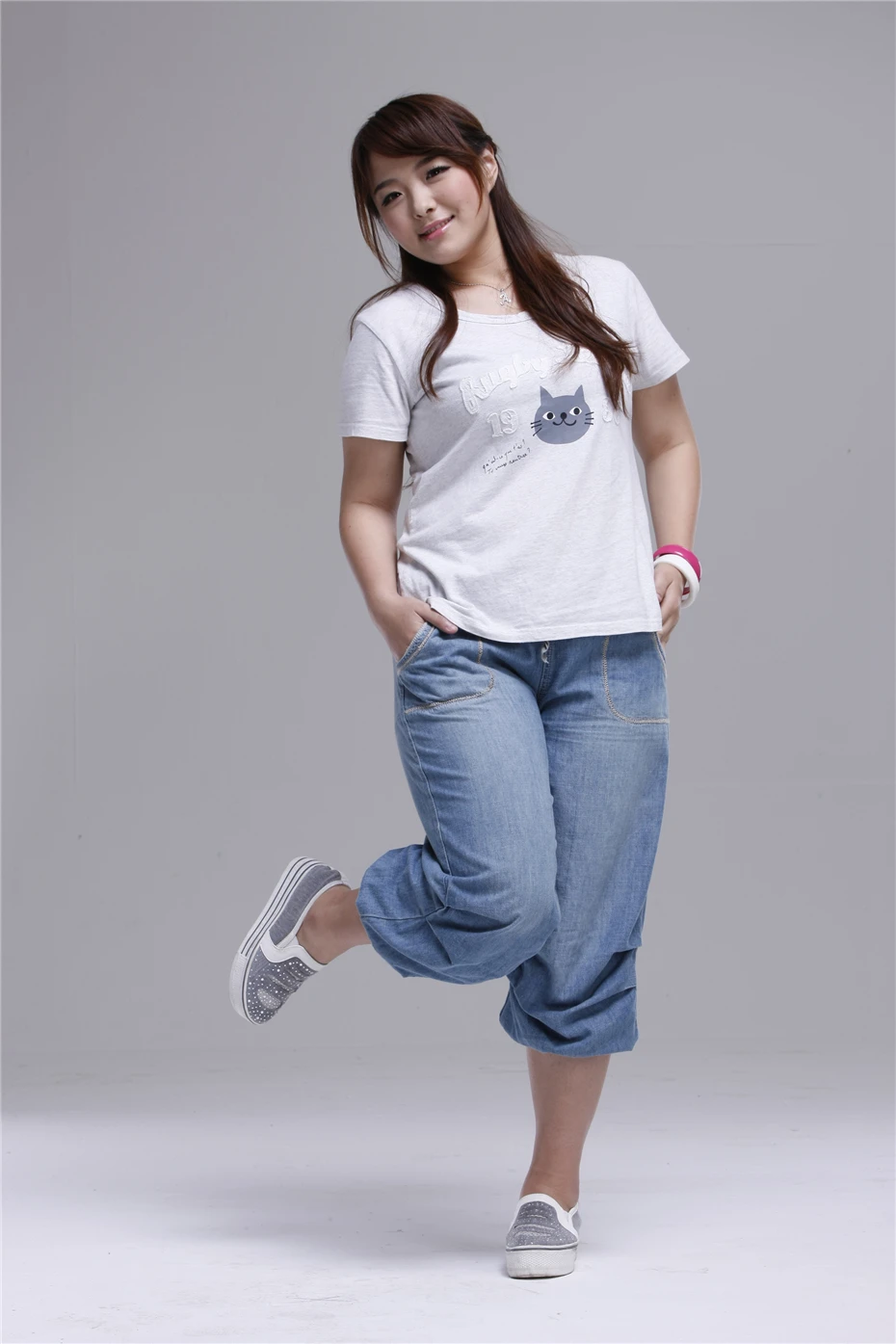 naine kannab helesiniseid teksapükse ja valget t-särki