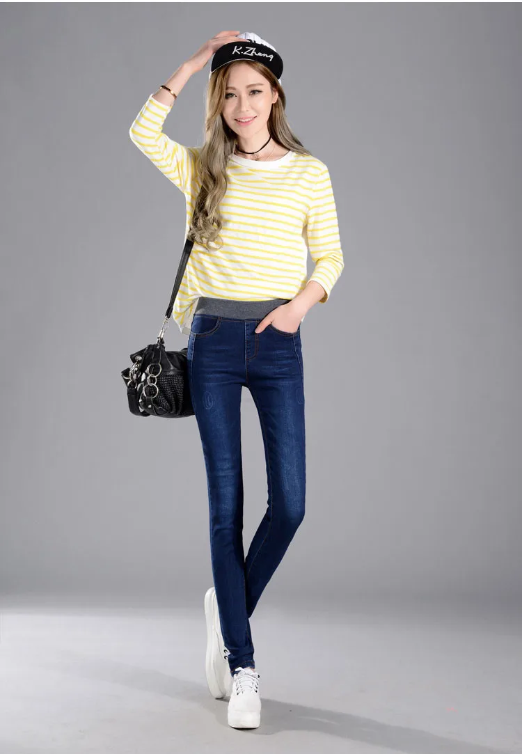 naine kannab tumesiniseid stretš teksaseid ja kollase-valge triibulist särki