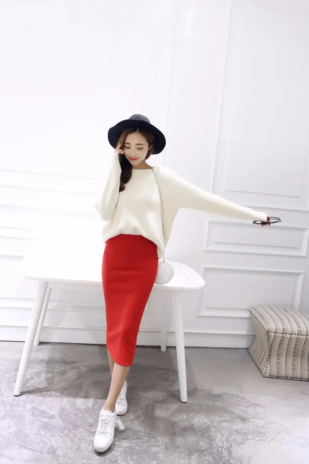 naine kannab punast pliiatsseelikut ja valget kampsunit