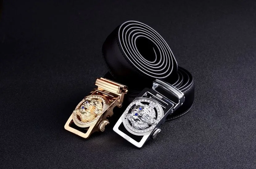 kaks musta nahast püksirihma, millel on kuldne ja hõbedane pannal hundi või jaaguariga