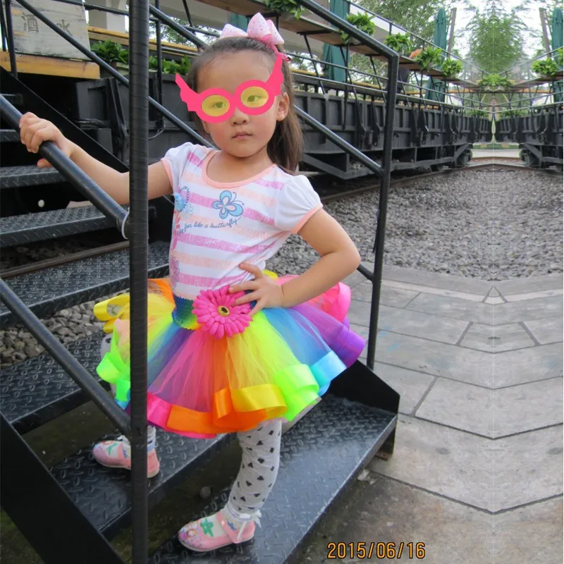 tüdruk kannab vikerkaare värvilist kohevust seelikut ja roosat maski