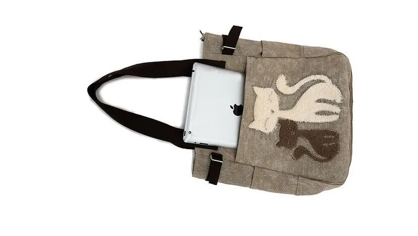 beež õlakott kahe kassikujutisega, millel on mustad sangad ja tasku